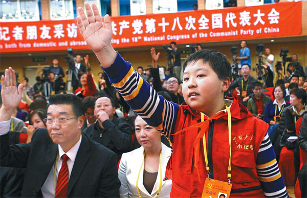 Zhang Jiahe, 11, a reporter from Chinese Teenagers News, attracts the attention of Minister of Housing and Urban-Rural Development Jiang Weixin during a news conference at the 18th Party Congress on Monday. He told the minister: 'Nowadays, houses are so expensive that many parents spend all their money on buying an apartment and even borrow lots of money from banks. They don't even have extra money to buy toys for their kids.' [Photo/China Daily] 
