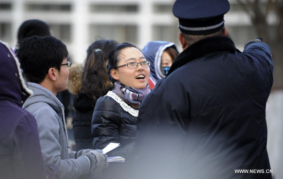 An examinee asks about the way to the examination room of the 2013 civil service exams in Yinchuan, capital of northwest China's Ningxia Hui Autonomous Region, Nov. 25, 2012. 