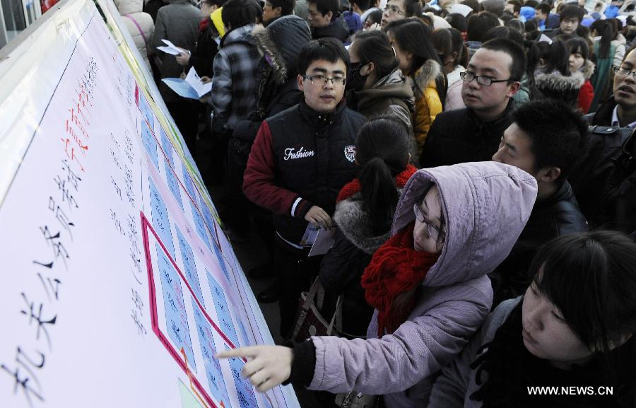 Applicants watch the map of examination rooms of the 2013 civil service exams in Yinchuan, capital of northwest China's Ningxia Hui Autonomous Region, Nov. 25, 2012. 