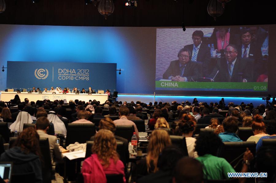 Xie Zhenhua (R, on screen), head of the Chinese delegation to Doha climate talks, makes a statement after the passing of the final agreements of the UN Climate Change Conference (COP 18/CMP 8) at the Qatar National Convention Center (QNCC) in Doha, Qatar, Dec. 8, 2012.