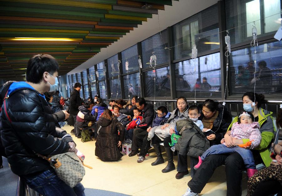 Parents accompany their children having IV drip at the temporary transfusion area of Beijing Children's Hospital in Beijing, capital of China, Jan. 13, 2013. 