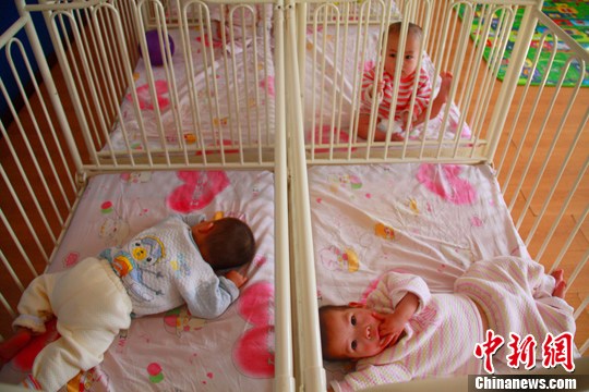 Babies are playing in a room at the Hohhot Children’s Welfare Institute.