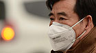 A man wears masks in fog-shrouded Jinan, capital of east China's Shandong Province, Feb. 25, 2013. Provincial meteorological authorities issued an orange fog alert on Monday morning.