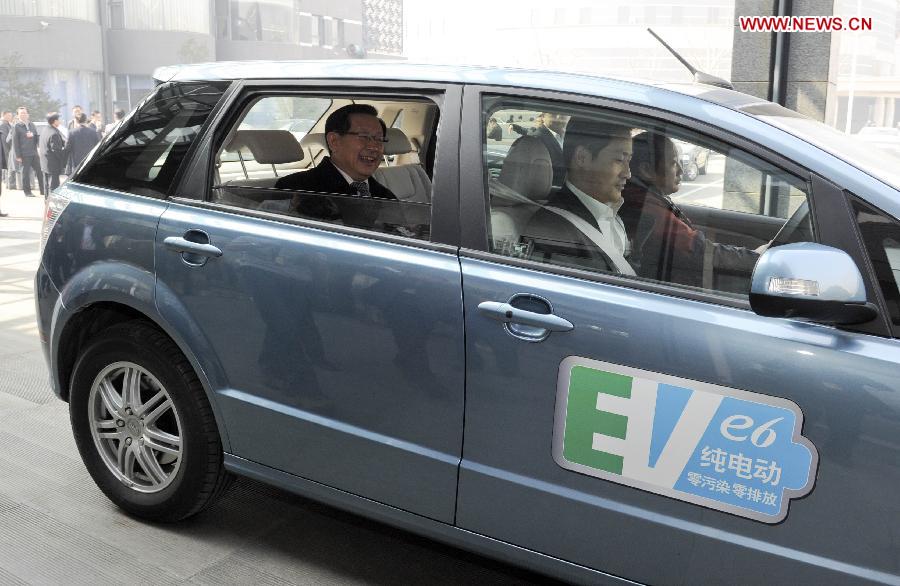 Wan Gang (L), the minister of science and technology, takes an electric vehicle (EV) to leave after a panel discussion in Beijing, capital of China, March 7, 2013. 