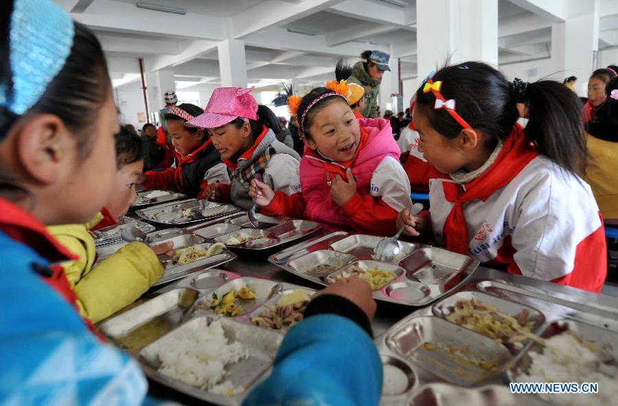 Pupils take their free lunch in the dining hall at No. 1 Primary School of Deqin County in Diqing Tibetan Autonomous Prefecture, southwest China's Yunnan Province, March 12, 2013. 