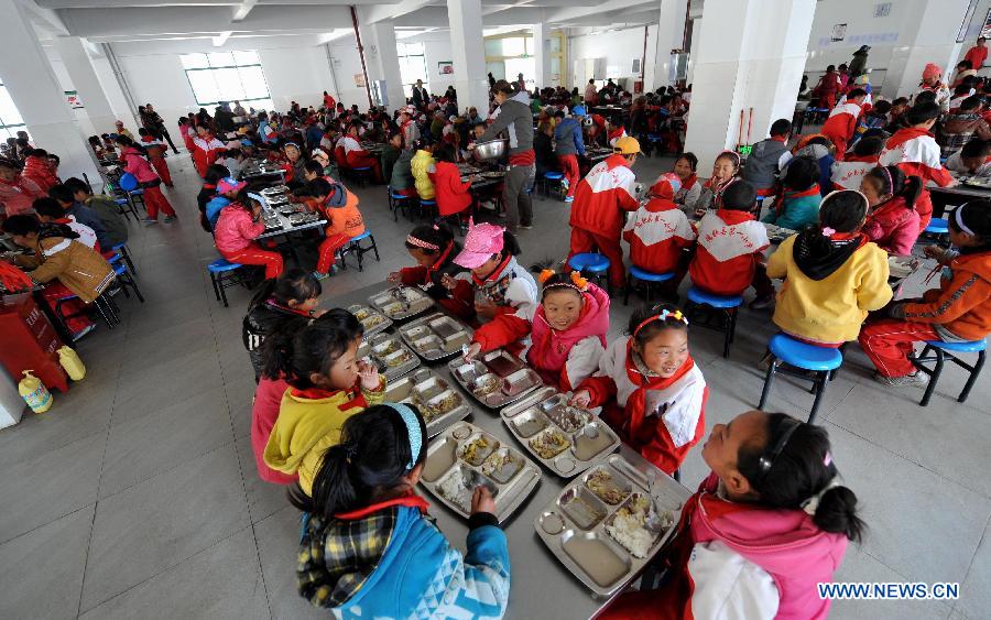 Pupils take their free lunch in the dining hall at No. 1 Primary School of Deqin County in Diqing Tibetan Autonomous Prefecture, southwest China's Yunnan Province, March 12, 2013. 