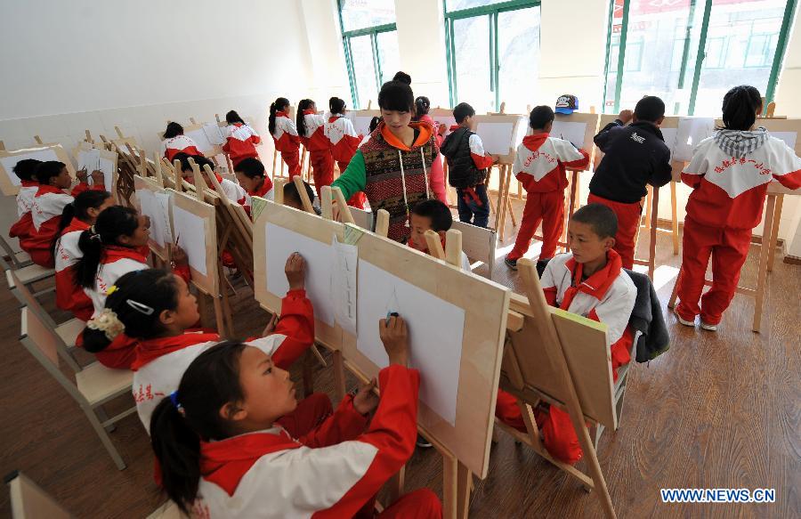 A teacher (C) of the Tibetan ethnic group gives an art class at No. 1 Primary School of Deqin County in Diqing Tibetan Autonomous Prefecture, southwest China's Yunnan Province, March 12, 2013.