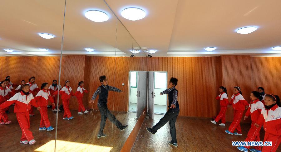 A teacher of the Tibetan ethnic group directs his students to practise folk dance at No. 1 Primary School of Deqin County in Diqing Tibetan Autonomous Prefecture, southwest China's Yunnan Province, March 12, 2013. 