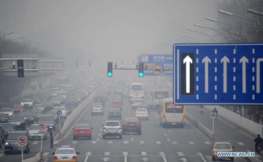 Vehicles run on a fog-shrouded road in Beijing, capital of China, March 17, 2013. 