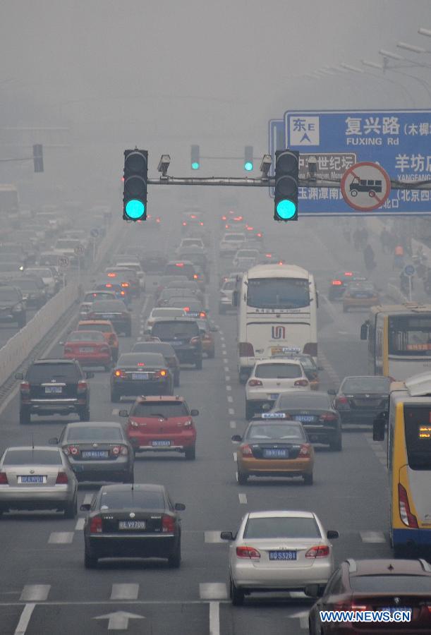 Vehicles run on a fog-shrouded road in Beijing, capital of China, March 17, 2013.