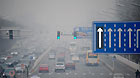 Vehicles run on a fog-shrouded road in Beijing, capital of China, March 17, 2013.