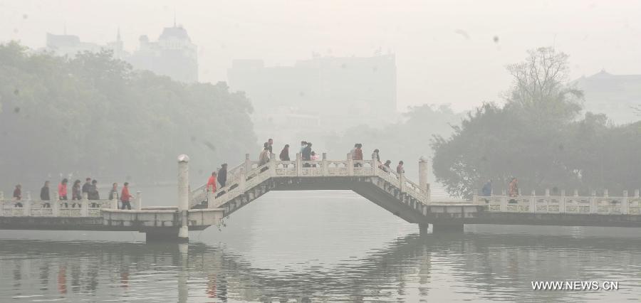 Tourists are seen on a bridge over the Ronghu Lake in Guilin, southwest China's Guangxi Zhuang Autonomous Region, March 17, 2013. 