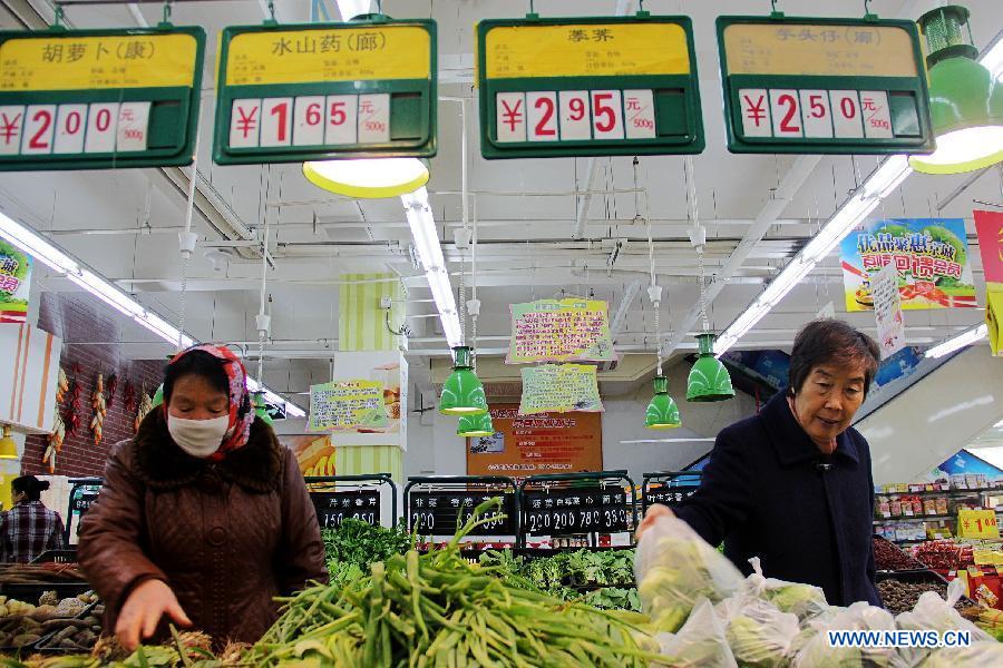 Consumers choose vegetables at a supermarket in Bazhou City, north China's Hebei Province, April 8, 2013. 