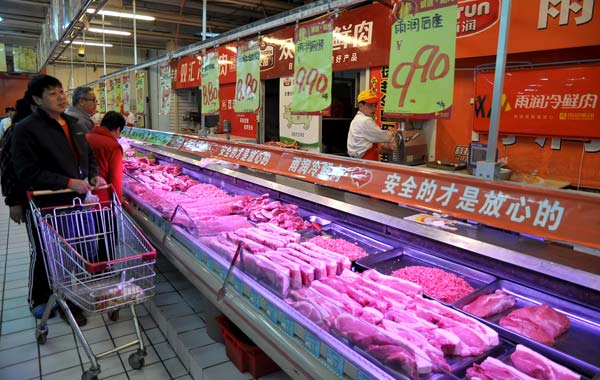 Customers look at pork and other meat at a supermarket in Handan, Hebei Province. Pork prices in 36 cities fell for six consecutive weeks up to April 1, and the government is increasing pork reserves to shore up the pig industry.