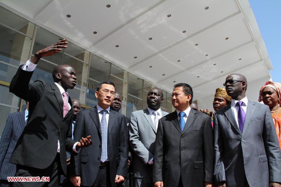 A Senegalese official (1st L) presents solar street lights to Chinese ambassador to Senegal Xia Huang (2nd R, Front) and Senegal's Transport and Infrastructure Minister Thierno Alassane Sall( 1st R, Front) in front of the National Assembly Building of Senegal in Dakar, capital of Senegal, April 16, 2013.