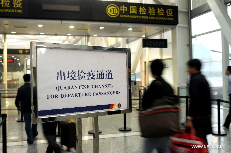 Passengers walk past quarantine channel for departure passengers at the Baiyun International Airport in Guangzhou, capital of south China's Guangdong Province, April 17, 2013. 