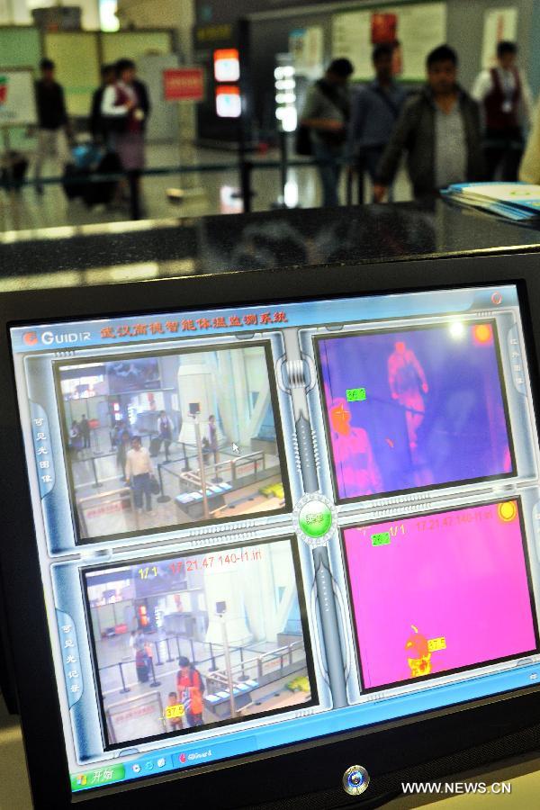 A screen shows passengers' temperature monitored by the infrared temperature measuring instrument at the Baiyun International Airport in Guangzhou, capital of south China's Guangdong Province, April 17, 2013. 