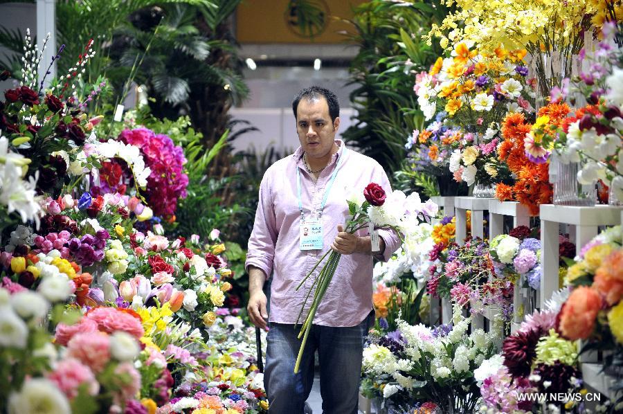 Rodrigo Quesada of Mexico purchases flowers at the 113th China Import and Export Fair, or Canton Fair, in Guangzhou, capital of south China's Guangdong Province, April 24, 2013.