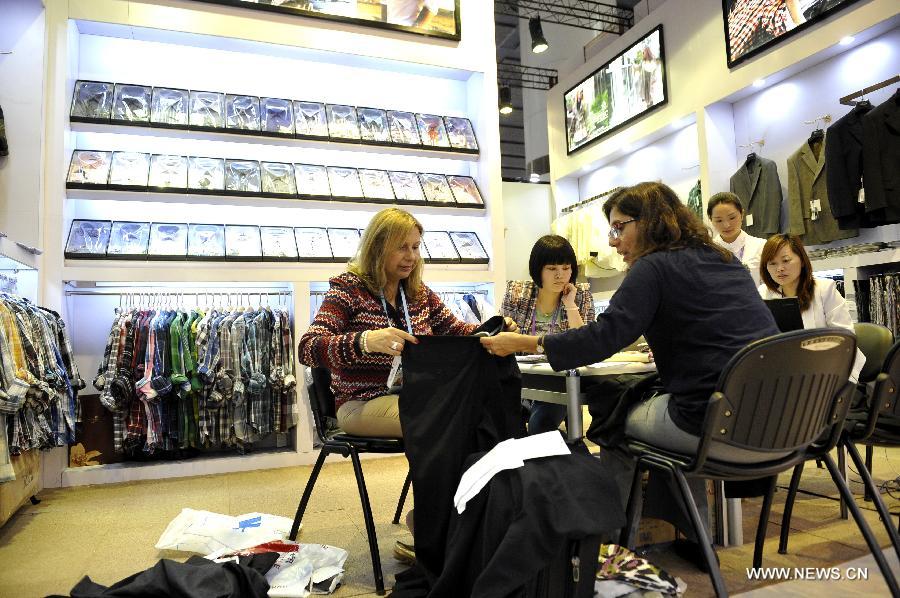 Roxana Villabona (1st L) and Sonia Costa (3rd L) of Uruguay purchases clothes at the 113th China Import and Export Fair, or Canton Fair, in Guangzhou, capital of south China's Guangdong Province, May 1, 2013.