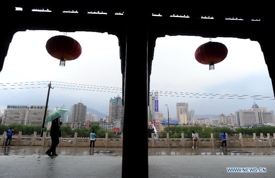Citizens visit a park in rain in Lanzhou, capital of northwest China's Gansu Province, May 8, 2013. 