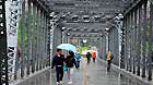 Citizens walk across a bridge in rain in Lanzhou, capital of northwest China's Gansu Province, May 8, 2013.