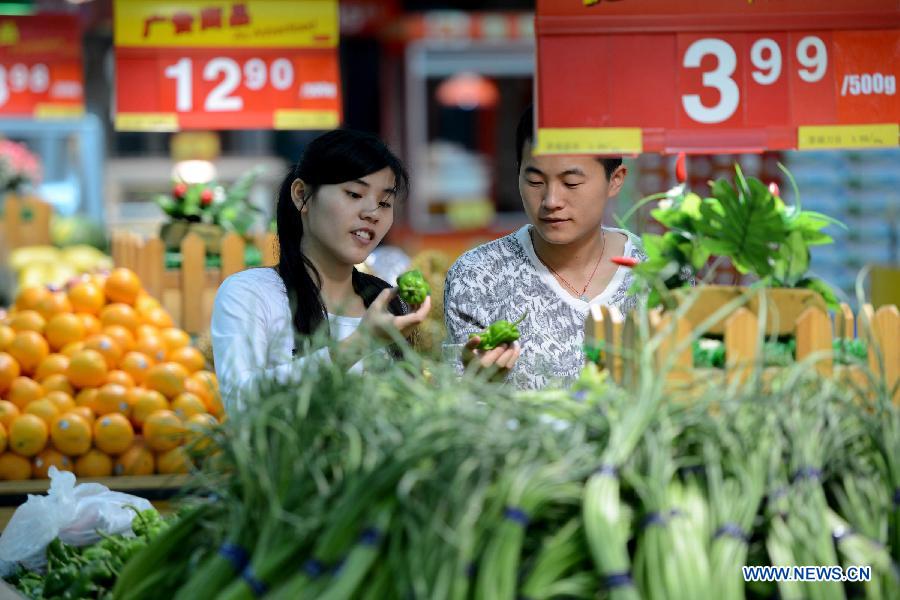 Consumers select vegetable at a supermarket in Hefei, capital of east China&apos;s Anhui Province, May 9, 2013.