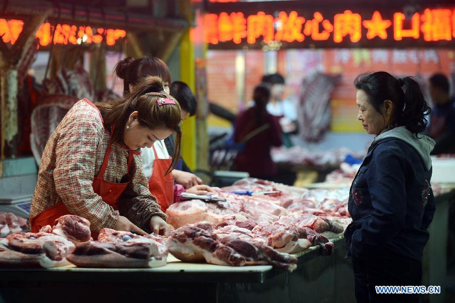 A consumer selects pork at a food market in Dehui City, northeast China's Jilin Province, May 9, 2013.