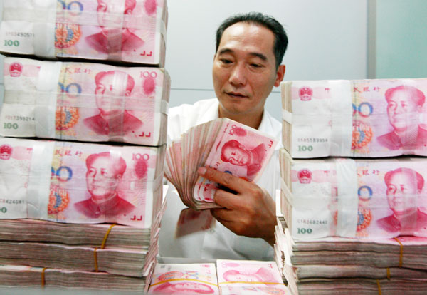 A worker counts and stacks banknotes at an Industrial and Commercial Bank of China branch in Huaibei, Anhui Province. The yuan is allowed to trade within 1 percent in each direction around the daily reference rate set by the central bank.