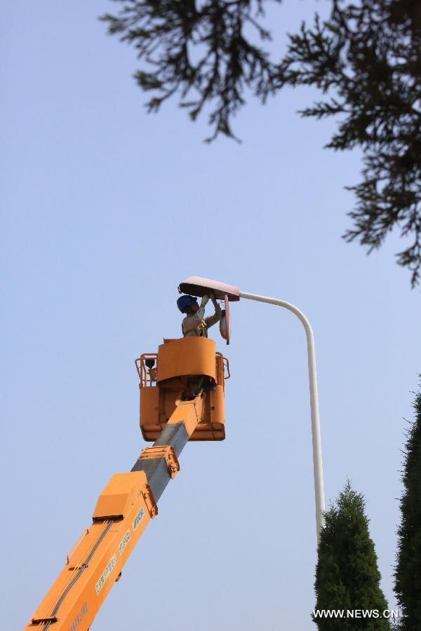 A worker fixes a light on Ziwei Road in Yongkang City, east China's Zhejiang Province, May 14, 2013. 