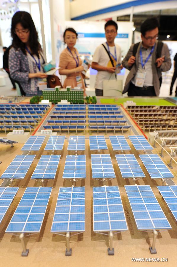 Visitors watch the models of photovoltaic products during the 2013 international photovoltaic exhibition in east China's Shanghai Municipality, May 14, 2013.