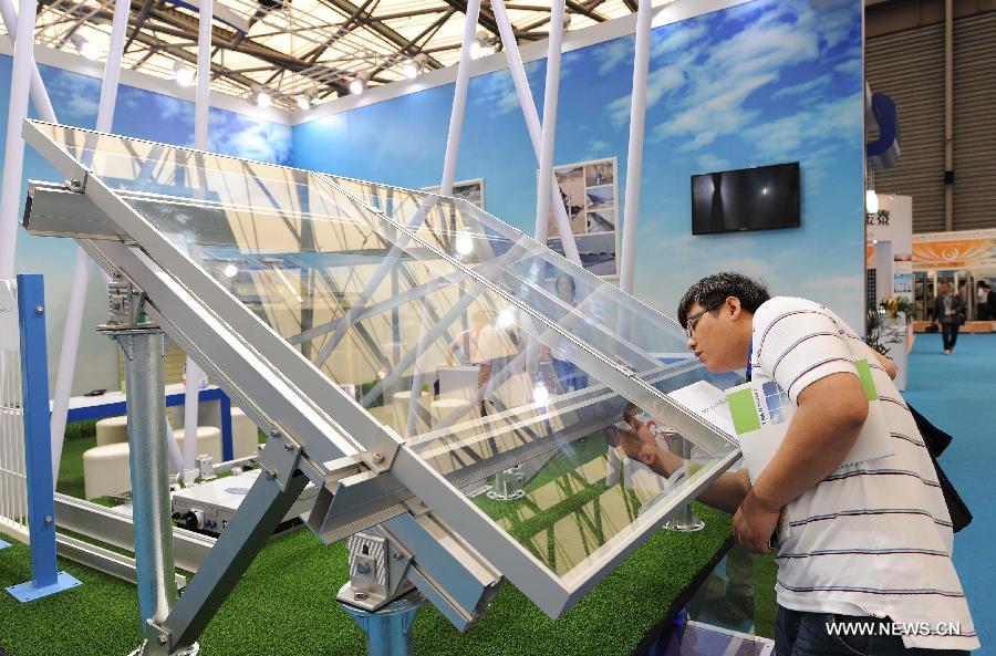 A visitor watches a photovoltaic product during the 2013 international photovoltaic exhibition in east China's Shanghai Municipality, May 14, 2013.