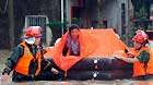 Rescuers evacuate stranded people in Yanshi Village of Shanwei City, south China's Guangdong Province, May 22, 2013.