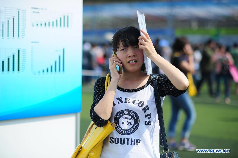 An applicant makes a phone call during a job fair in Guizhou University of Finance and Economics in Guiyang, capital of southwest China's Guizhou Province, May 23, 2013.