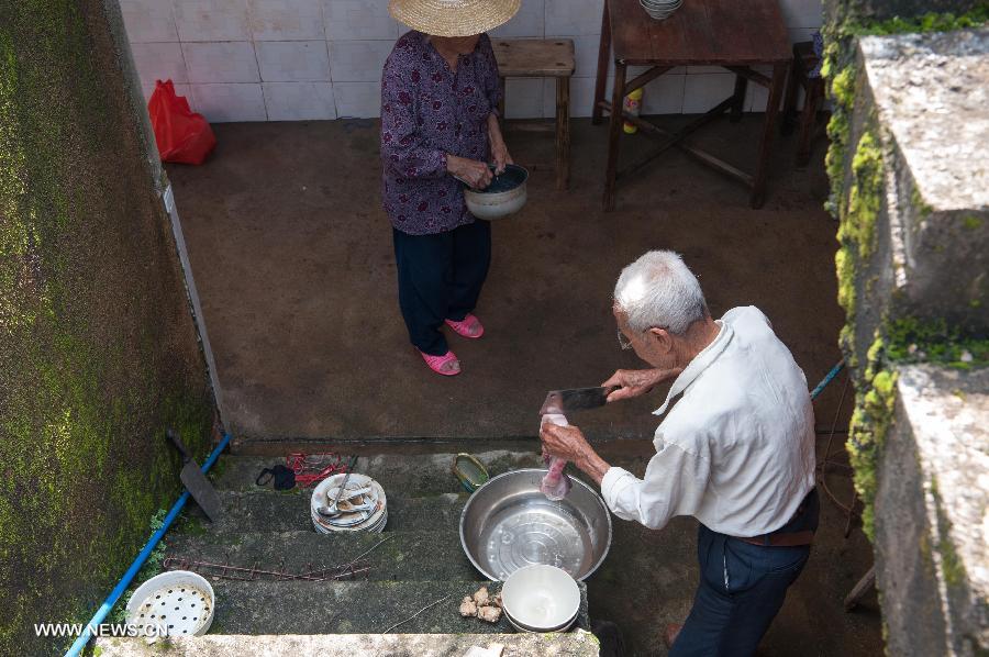 Qiu Xianghai (R), 84, and his wife Lai Guixiang, 82, prepare for cooking in Hongxing Village of Jiaoling County, Meizhou City, South China's Guangdong Province, May 23, 2013. 