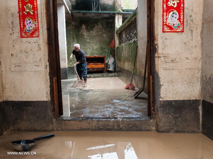 Zhong Yongxiang, 59, cleans his flooded house in Legan Village of Jiaoling County, Meizhou City, South China's Guangdong Province, May 23, 2013. 