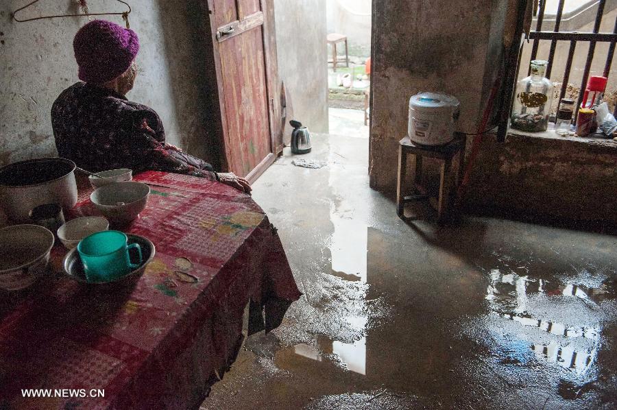 A woman aged over 90 sits in her flooded house in Daba Village of Jiaoling County, Meizhou City, South China's Guangdong Province, May 22, 2013.