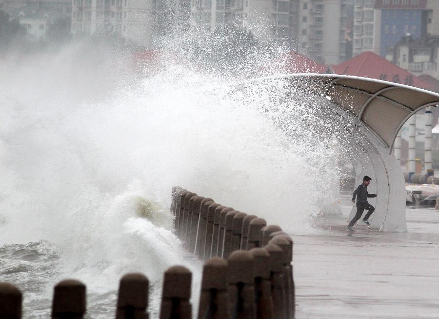 A man runs away from the wave in Yantai City, east China's Shandong Province, May 27, 2013. 