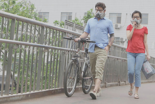 A couple walk in the haze wearing breathing masks at an overpass near Beijing Forestry University.