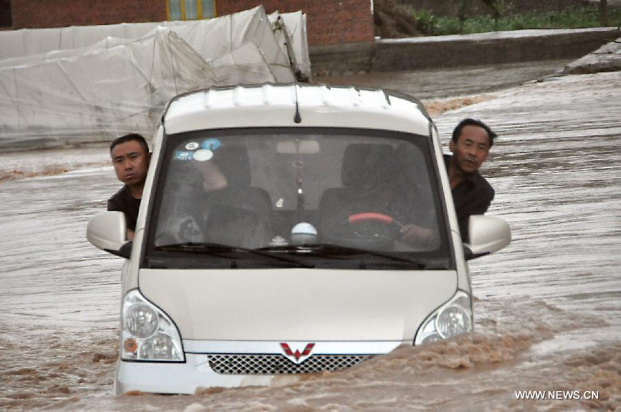 A vehicle is trapped in the rain-triggered flood in Changba Village of Bijie City, southwest China's Guizhou Province, May 29, 2013. 