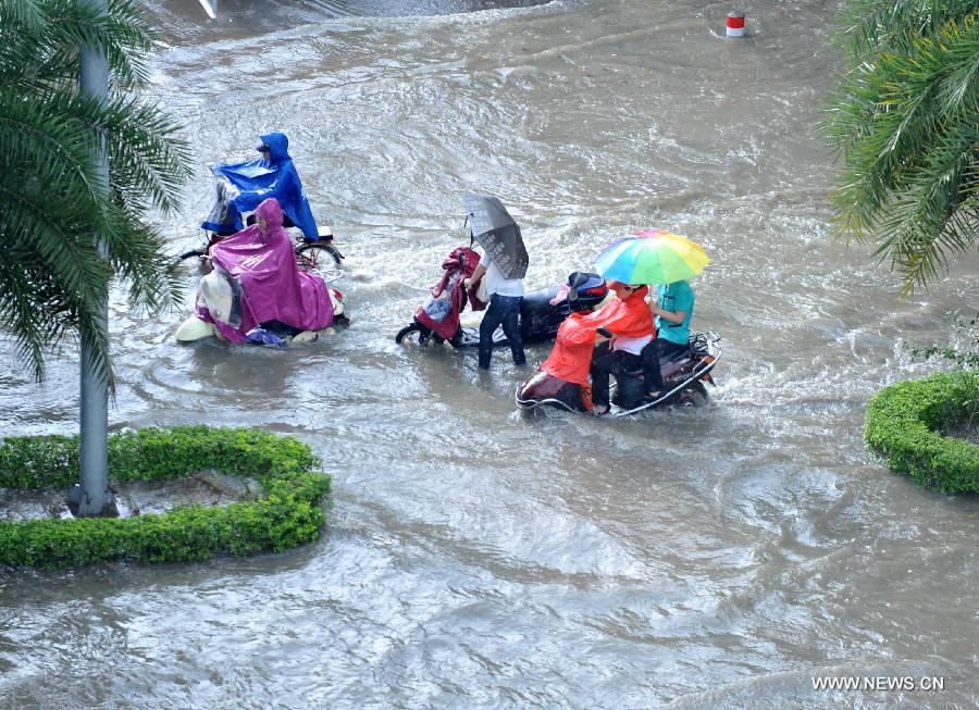 People ride in floods in Nanning City, south China's Guangxi Zhuang Autonomous Region, June 4, 2013. 