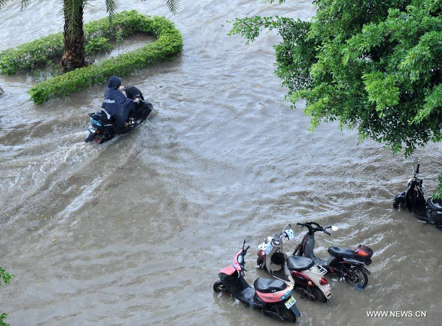 A man rides an electric bike in floods in Nanning City, south China's Guangxi Zhuang Autonomous Region, June 4, 2013. 