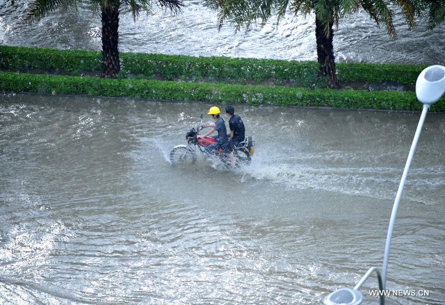 People ride in floods in Nanning City, south China's Guangxi Zhuang Autonomous Region, June 4, 2013. 