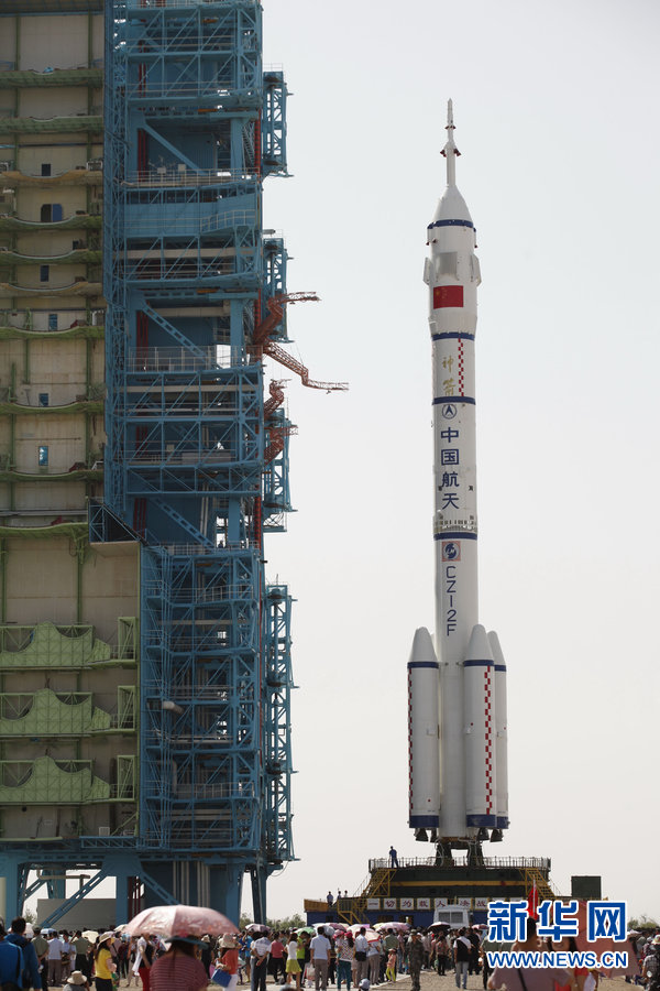 The Shenzhou 10 spacecraft, atop its Long March-2F carrier rocket booster, has been vertically transferred from a preparation area to the launch pad at the Jiuquan Satellite Launch Center in the Gobi desert. 