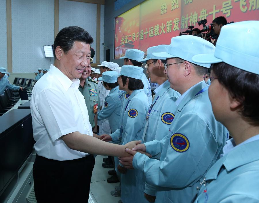Chinese President Xi Jinping(R), also general secretary of the Central Committee of the Communist Party of China (CPC) and chairman of the Central Military Commission (CMC), shakes hands with those participating in the program of Shenzhou-10 manned spacecraft and sending his warm greetings to them at the Jiuquan Satellite Launch Center in Jiuquan, northwest China's Gansu Province, June 11, 2013.