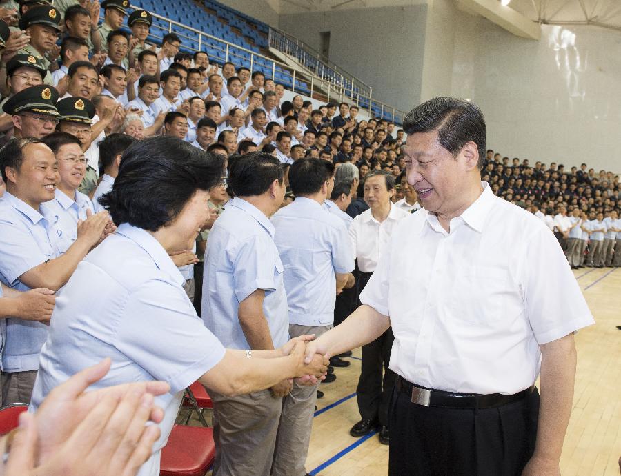Chinese President Xi Jinping(R), also general secretary of the Central Committee of the Communist Party of China (CPC) and chairman of the Central Military Commission (CMC), shakes hands with those participating in the program of Shenzhou-10 manned spacecraft and sending his warm greetings to them at the Jiuquan Satellite Launch Center in Jiuquan, northwest China's Gansu Province, June 11, 2013.