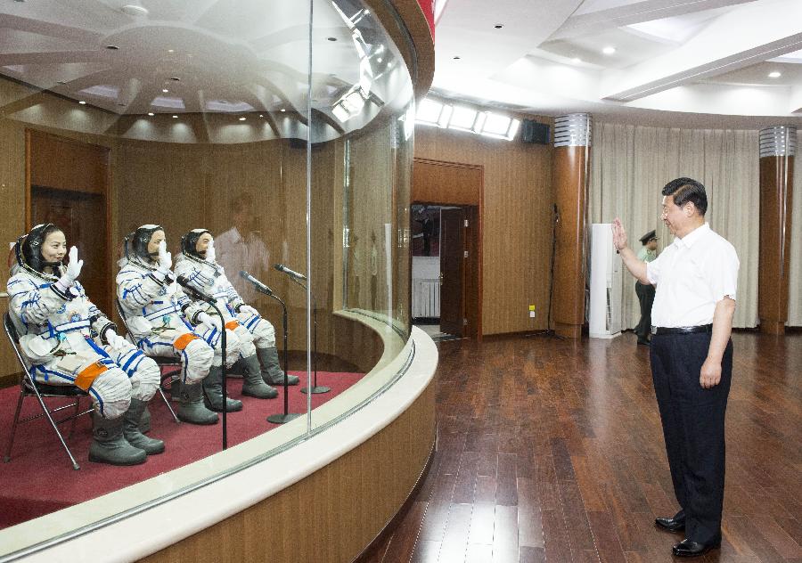 Chinese President Xi Jinping(R), also general secretary of the Central Committee of the Communist Party of China (CPC) and chairman of the Central Military Commission (CMC), shakes hands with those participating in the program of Shenzhou-10 manned spacecraft and sending his warm greetings to them at the Jiuquan Satellite Launch Center in Jiuquan, northwest China's Gansu Province, June 11, 2013.