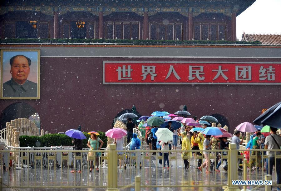 Visitors walk past the Tian'anmen Rostrum in rain and hail in Beijing, capital of Beijing, June 11, 2013. (Xinhua/Chen Yehua) 