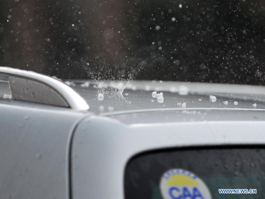 Hail falls on the roof of a vehicle in Beijing, capital of Beijing, June 11, 2013.