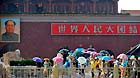 Visitors walk past the Tian'anmen Rostrum in rain and hail in Beijing, capital of Beijing, June 11, 2013.