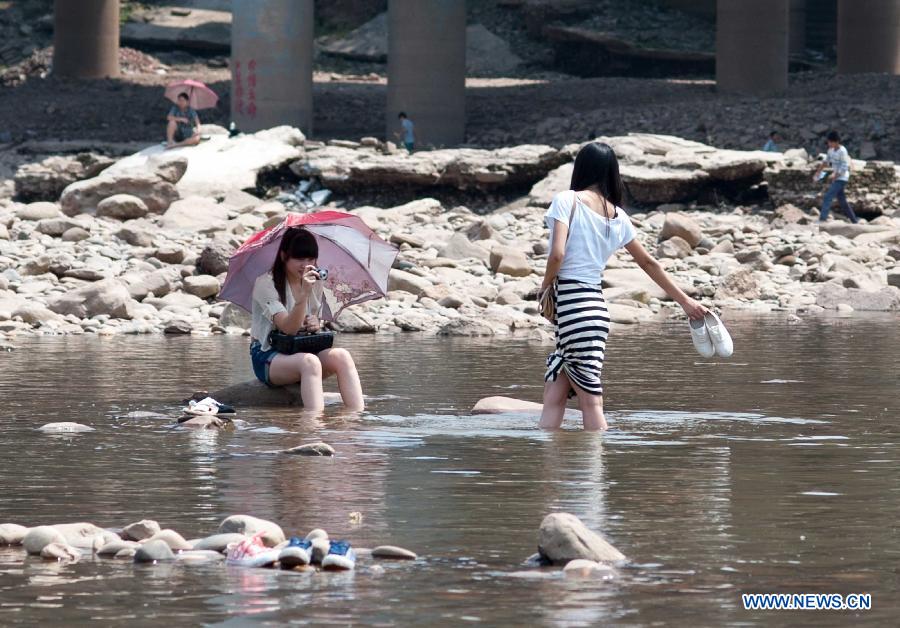Girls cool themselves off in the Jialingjiang River at Ciqikou Town in Chongqing, southwest China's municipality, June 16, 2013. Local meteorological authorities issued an orange-coded alert of heat on Sunday, which indicates the temperature will rise up to 37 degrees Celsius Sunday afternoon. (Xinhua/Liu Chan) 